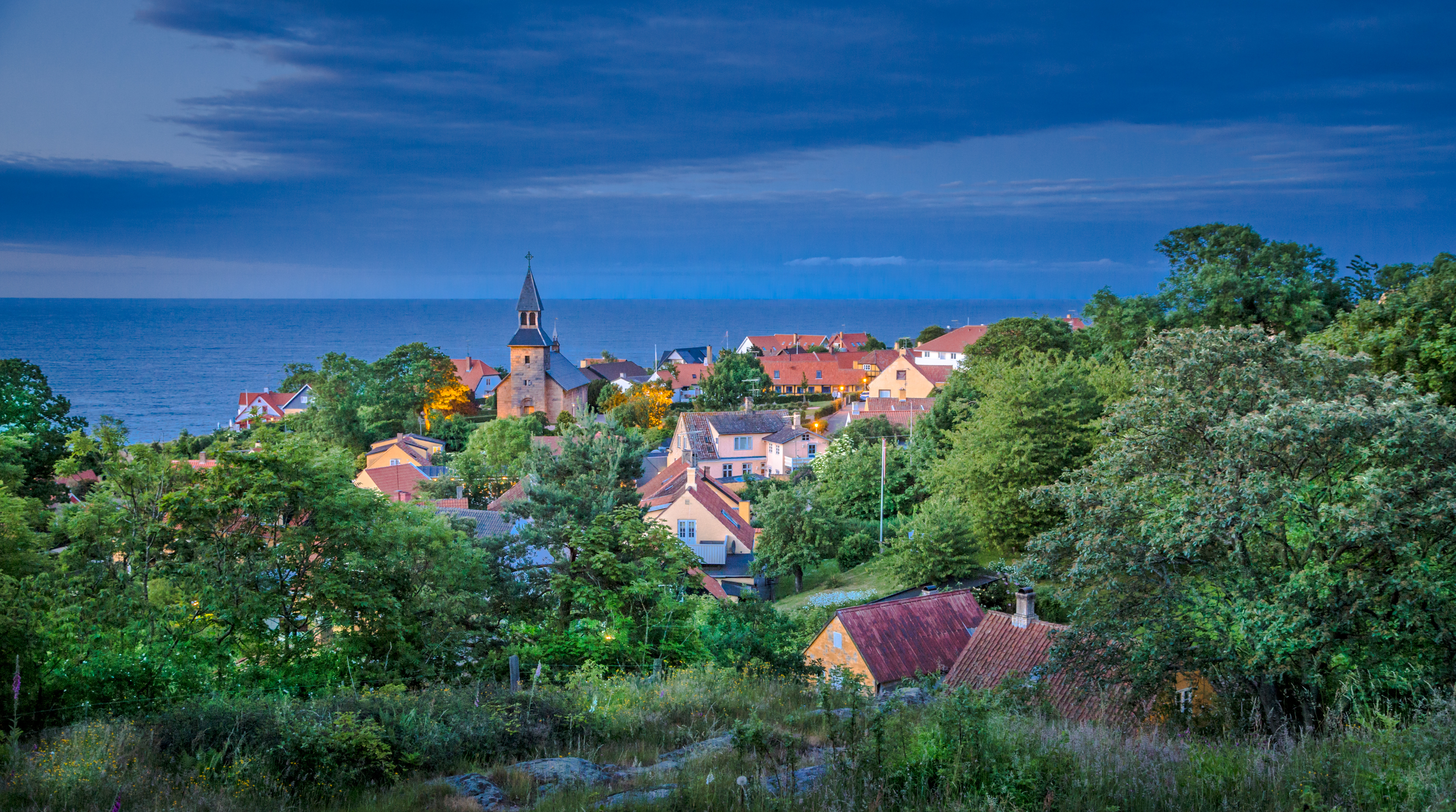 Udsigt over Gudhjem by med kirken og havet i fokus