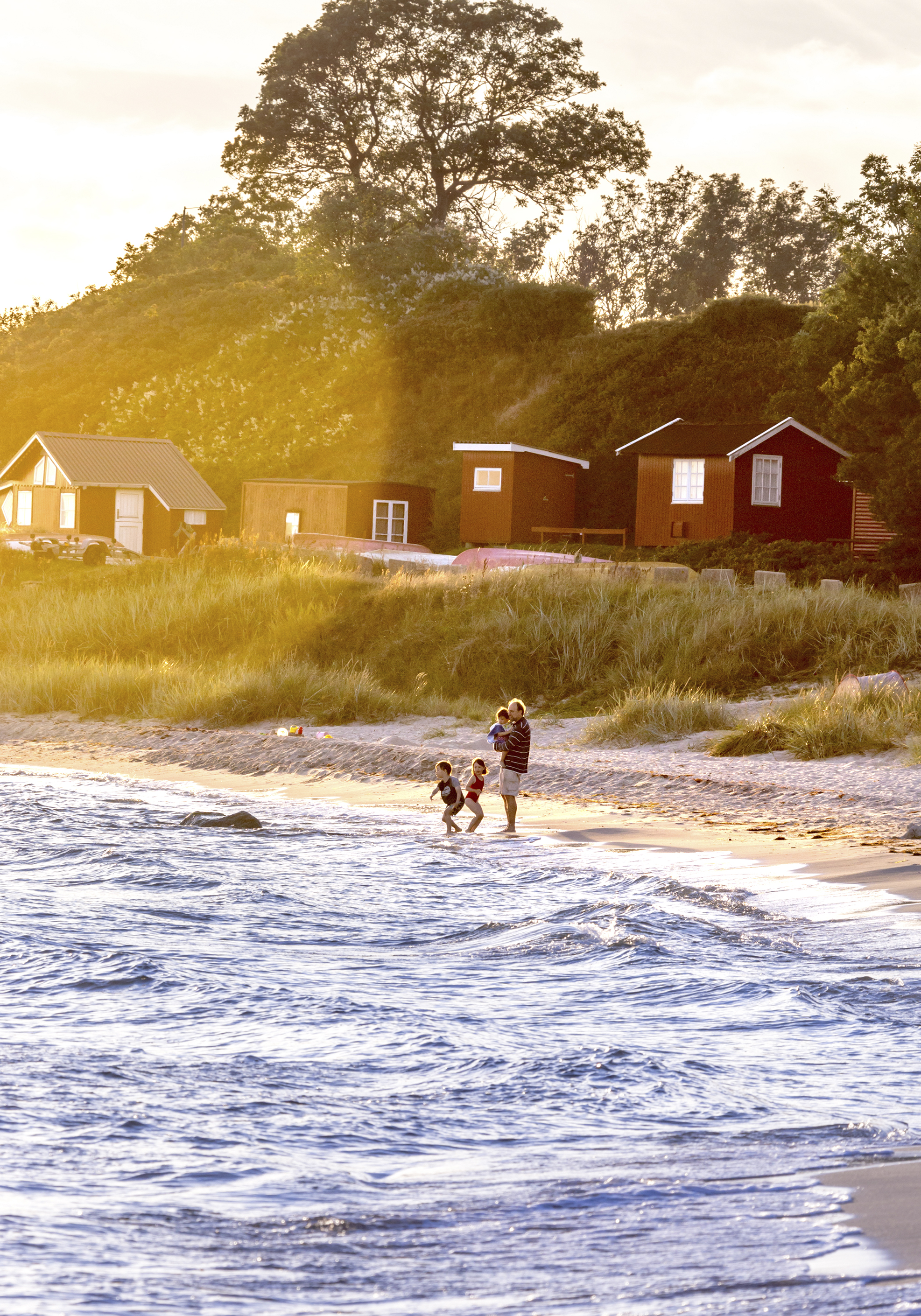 Hygge i strandkanten med de små bådshuse i baggrunden