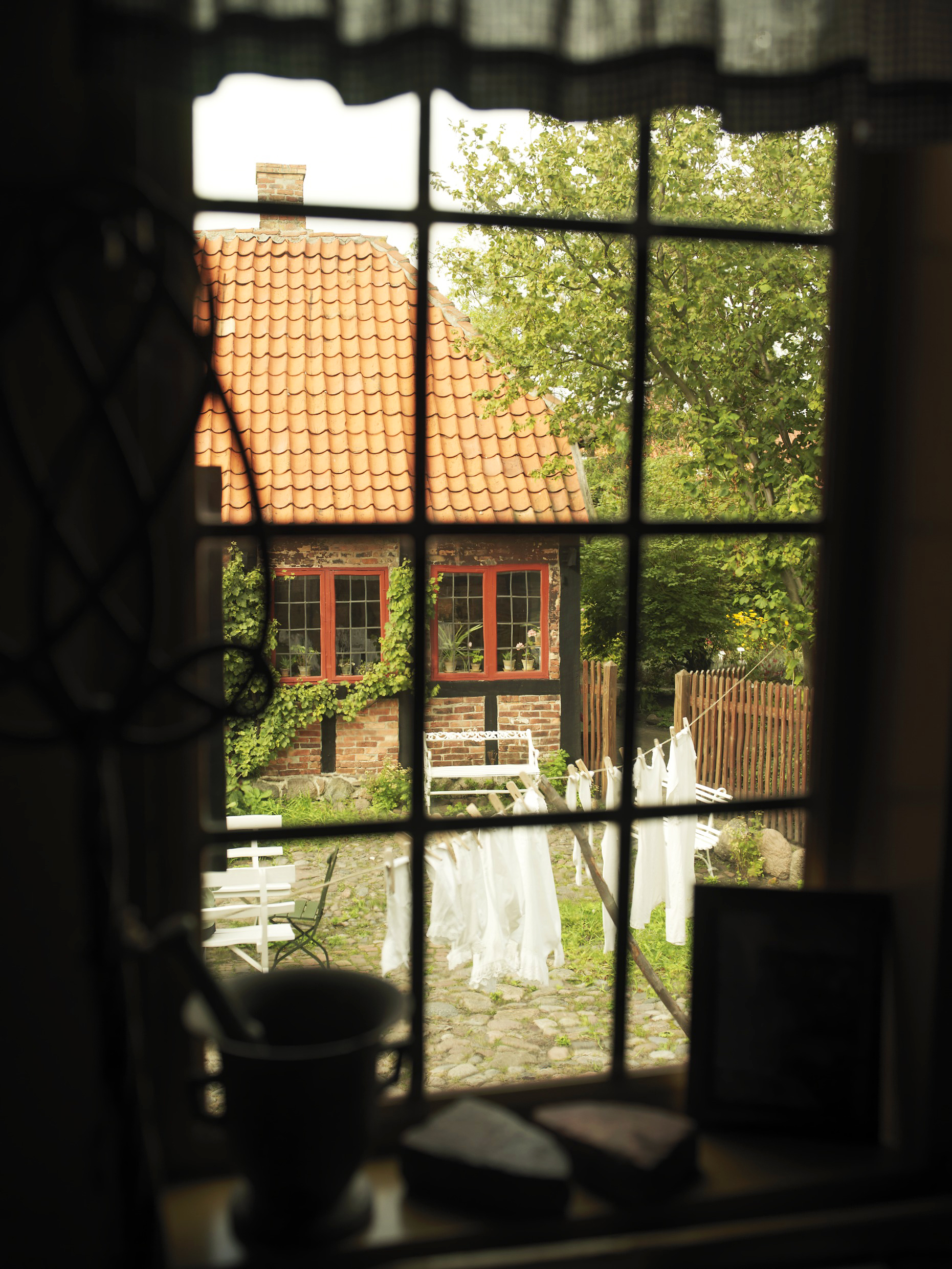 Et kig ud i gården fra et vindue på museet Erichsens Gård i Rønne